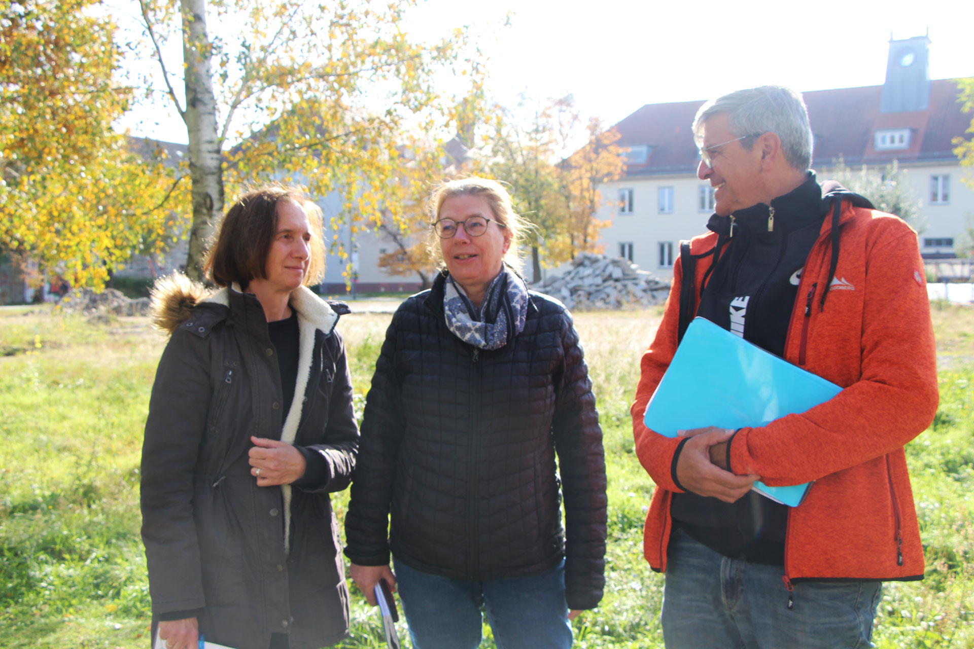 Marion Hardel, Patrizia Reicherl und Matthias Schreckenbach stehen auf der Mensawiese der FH Potsdam. Im Hintergrund sind die alten Hochschulgebäude zu sehen.