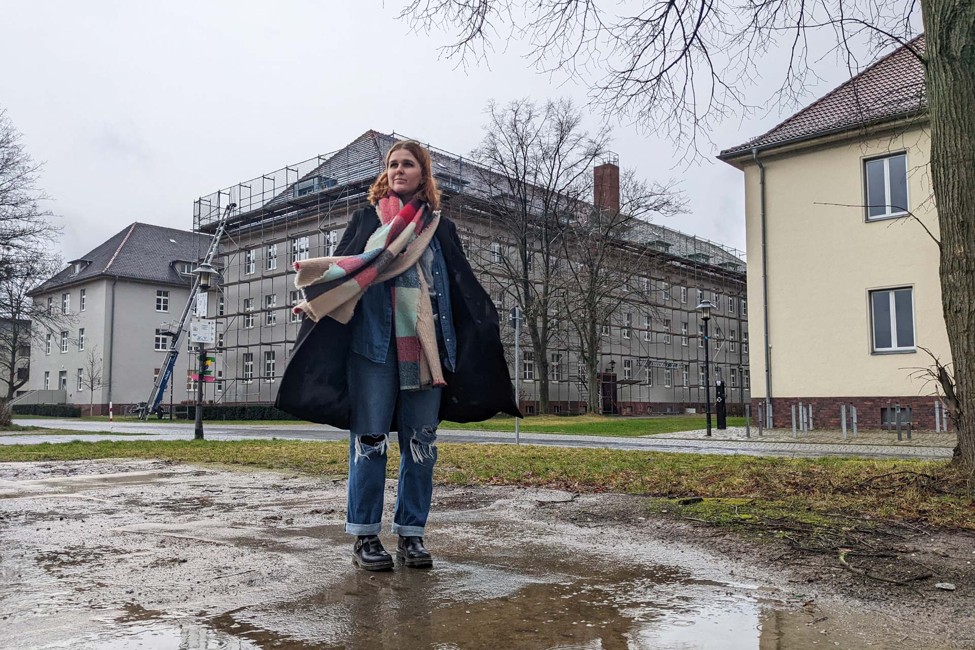 Elena Langer steht auf dem Gelände der FH Potsdam, im Hintergrund sind Hochschulgebäude zu sehen.
